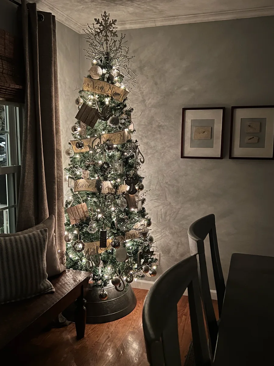 A silvery Christmas tree with ribbon lettering and dimensional ornaments.